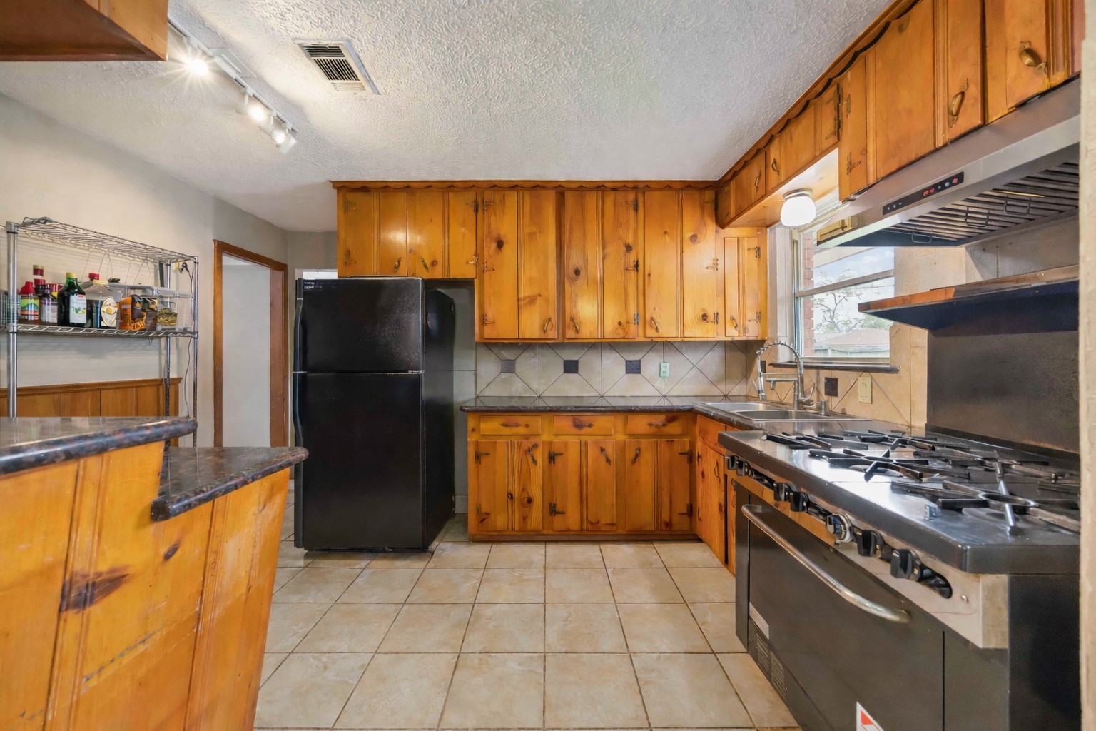 4501 Verdome Lane Houston, TX 77092 - Photo 9 of 27 a kitchen with a stove a refrigerator and storage