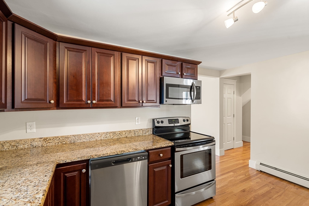 12 Chestnut Street Danvers, MA 01923 - Photo 34 of 37 a kitchen with stainless steel appliances granite countertop a stove a sink and a microwave