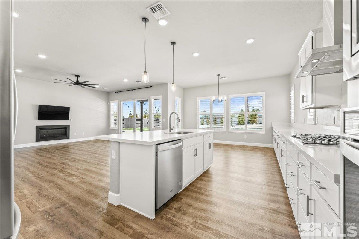 1273 Crawford Crk Drive Reno, NV 89521 - Photo 11 of 39 a large kitchen with kitchen island a stove a sink a center island and wooden floor