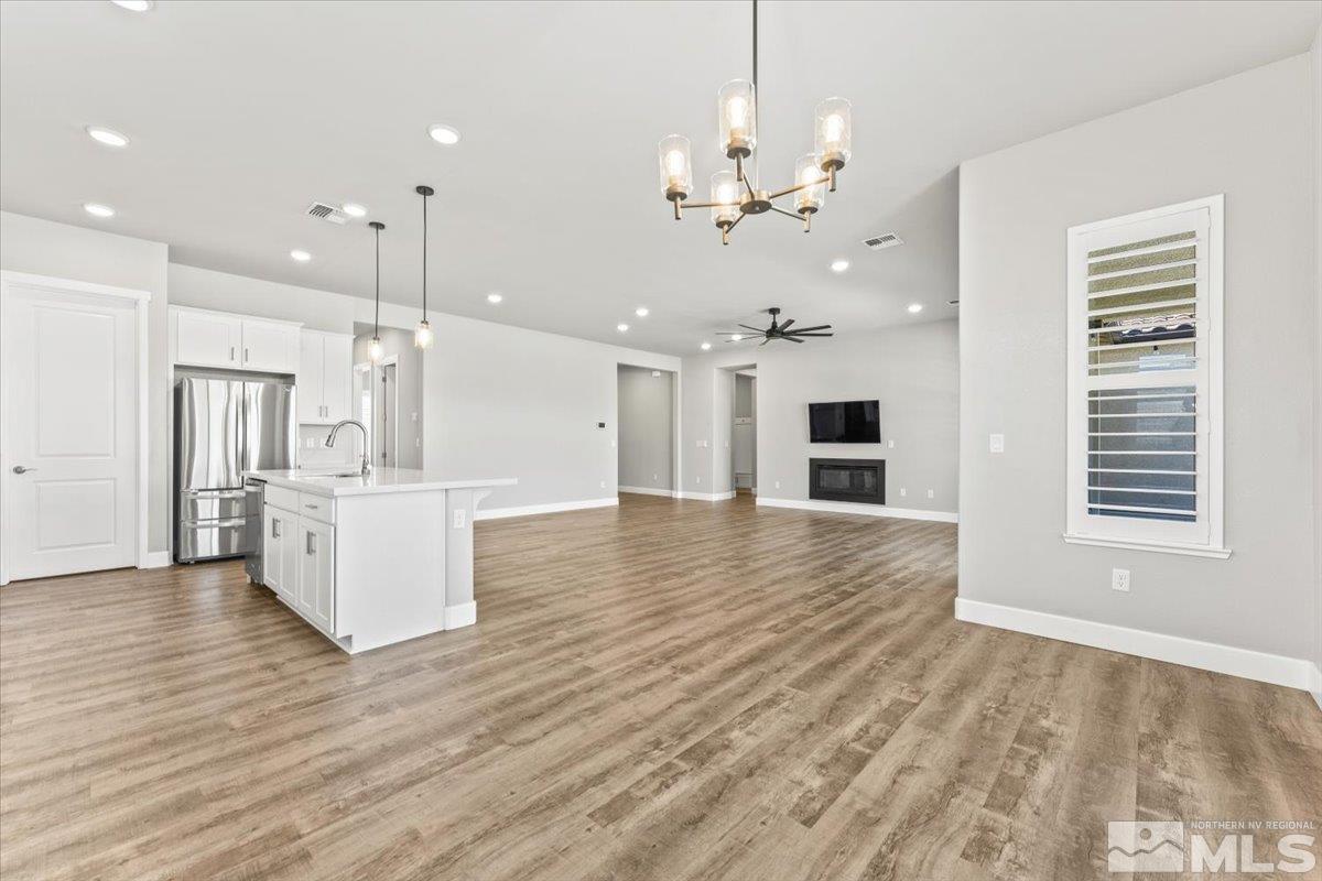 1273 Crawford Crk Drive Reno, NV 89521 - Photo 12 of 39 a view of a kitchen with a kitchen island wooden floor stainless steel appliances and a ceiling fan
