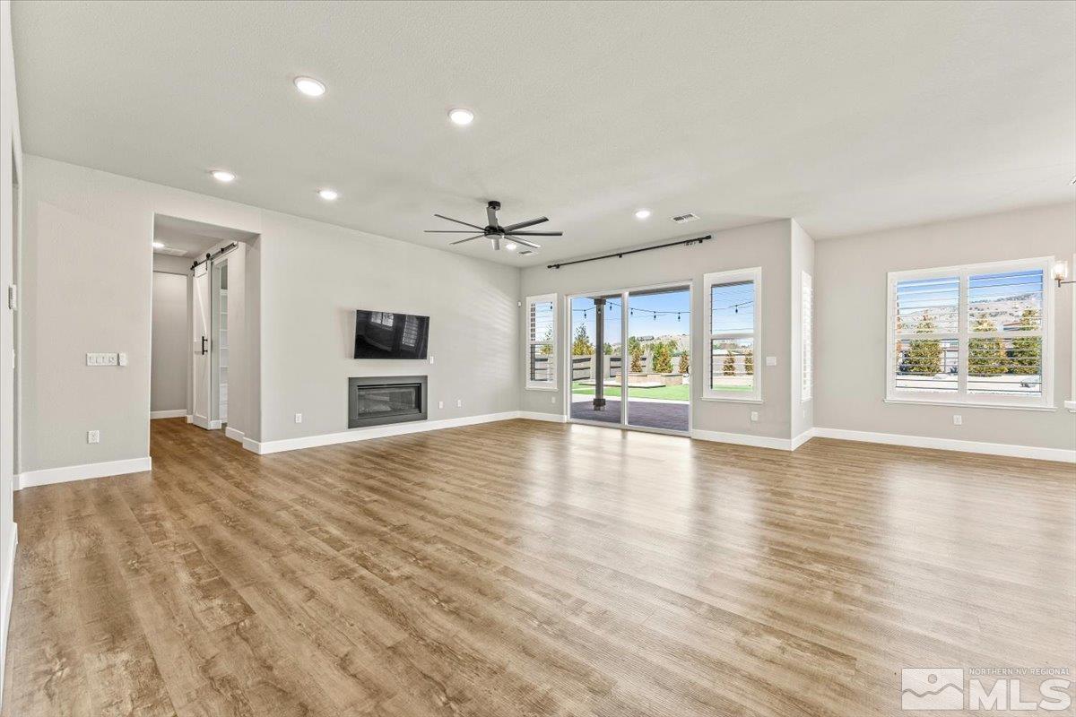 1273 Crawford Crk Drive Reno, NV 89521 - Photo 6 of 39 a view of an empty room with a window and wooden floor