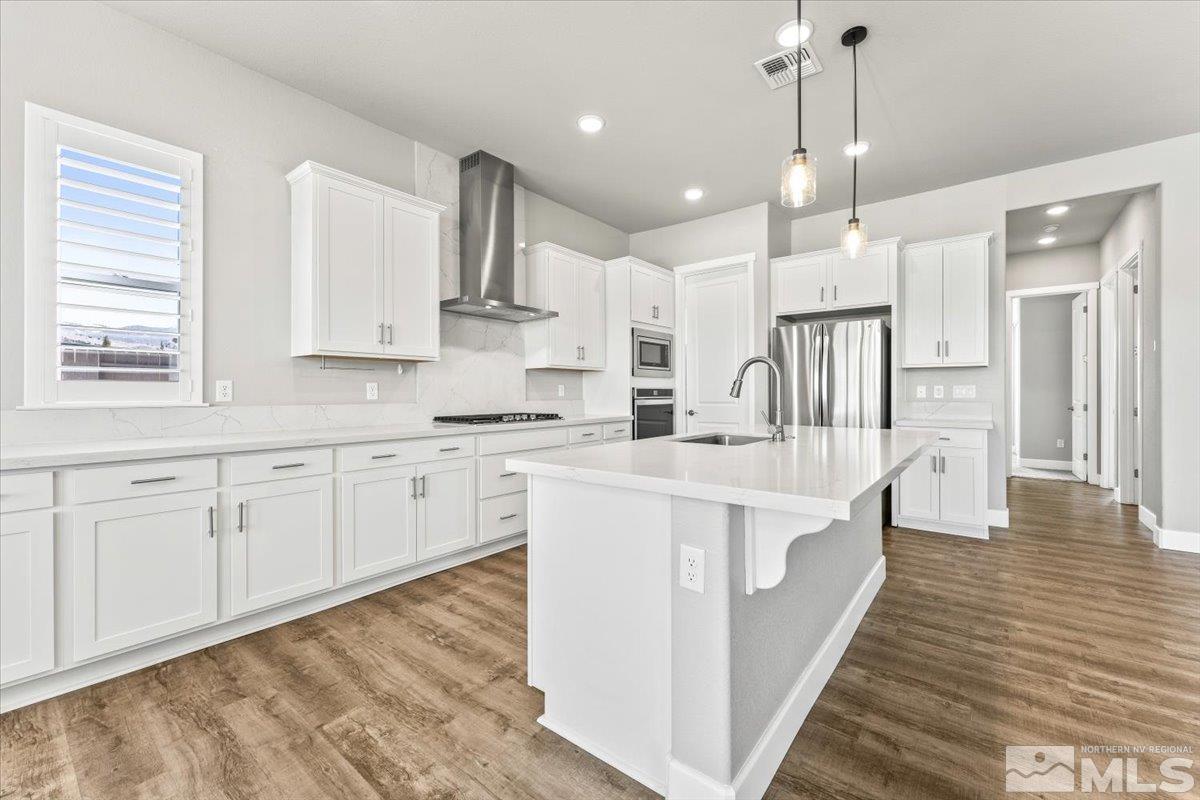 1273 Crawford Crk Drive Reno, NV 89521 - Photo 10 of 39 a large white kitchen with lots of counter space wooden floor and appliances