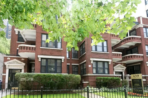 a front view of a residential apartment building with a yard