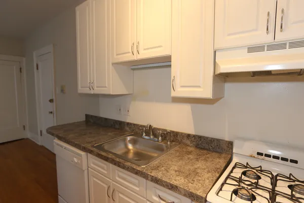 a kitchen with granite countertop a sink and a stove