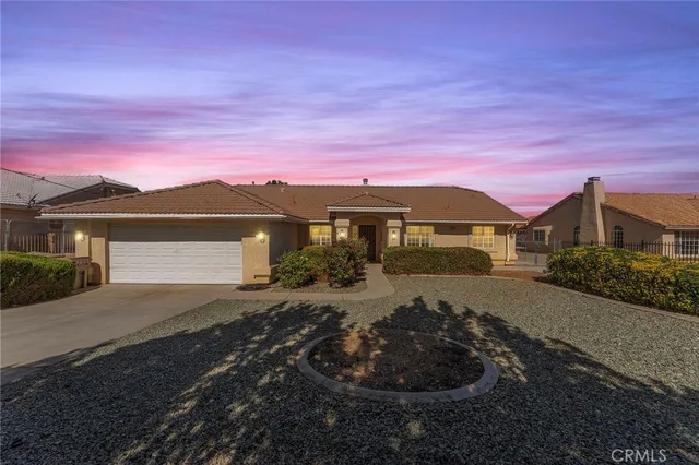 a front view of a house with a yard and mountain view