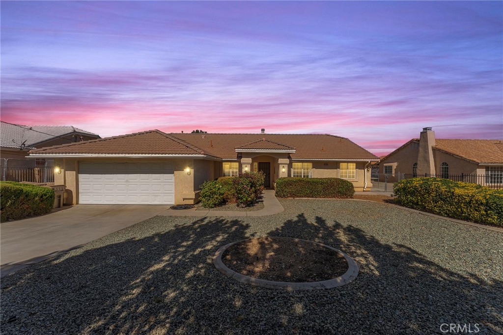 a front view of a house with a yard and mountain view