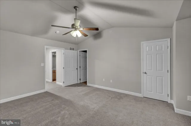 a view of an empty room and a ceiling fan window