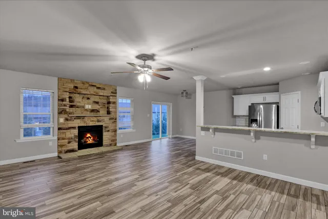 a view of a livingroom with a fireplace a chandelier and wooden floor