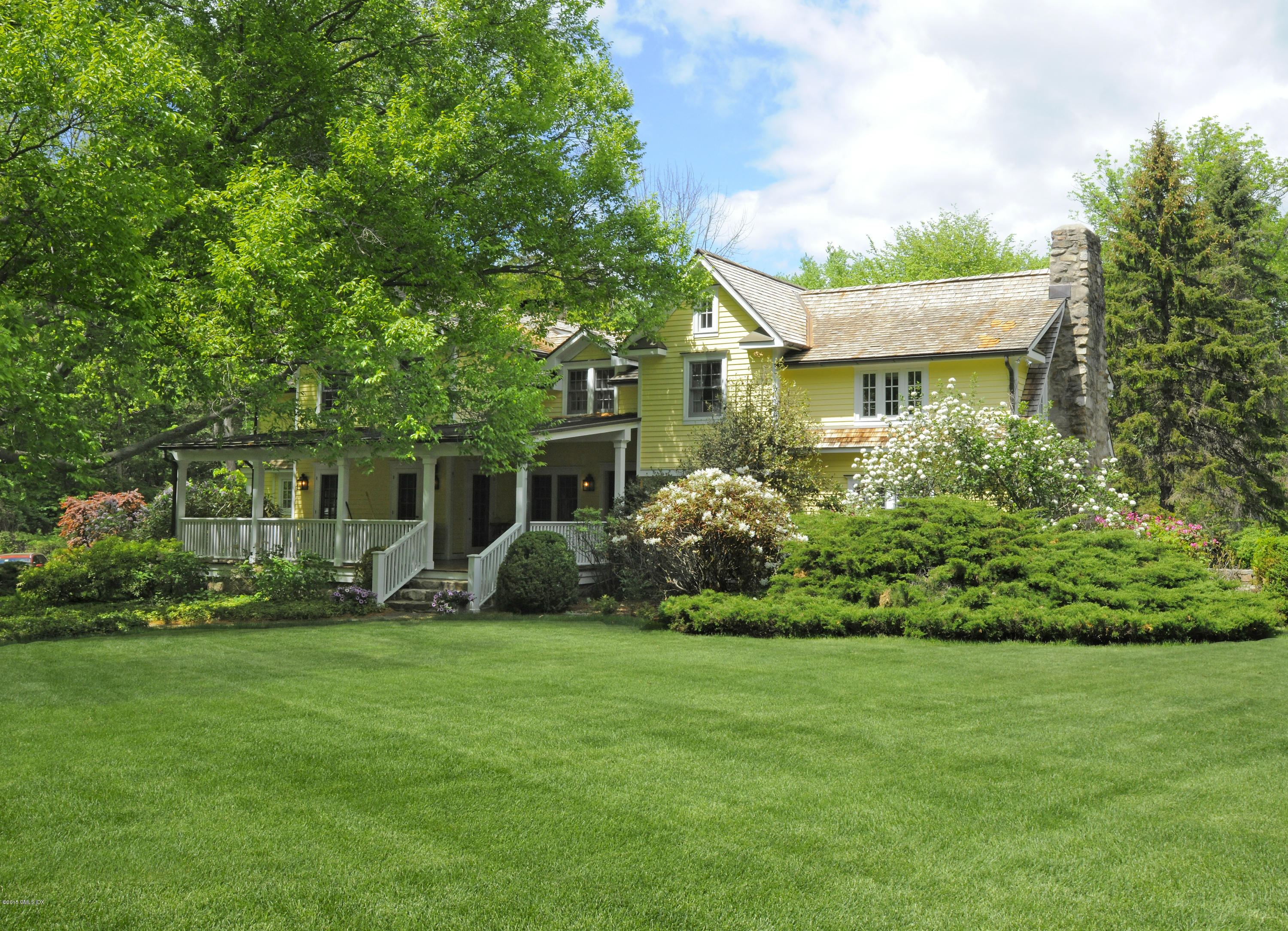 a front view of a house with a garden and trees