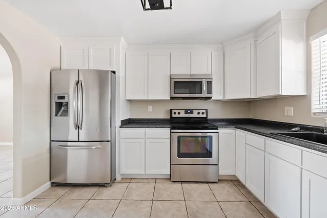 a kitchen with cabinets stainless steel appliances and a window
