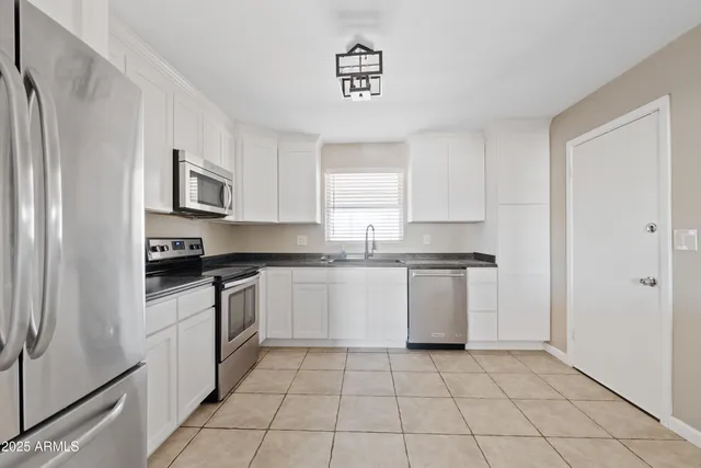 a kitchen with stainless steel appliances granite countertop a refrigerator stove a sink and microwave