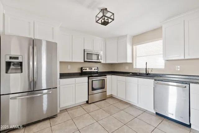 a kitchen with granite countertop white cabinets and sink