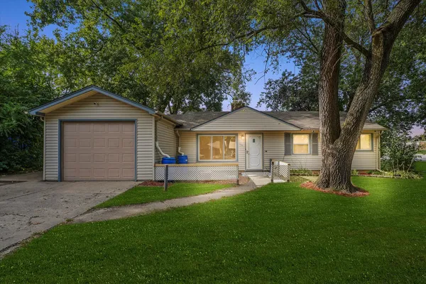 a front view of a house with a garden and trees