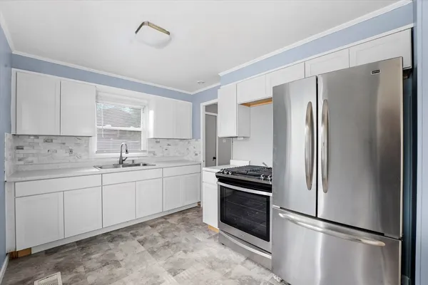 a kitchen with stainless steel appliances a refrigerator sink and cabinets