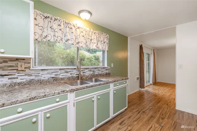 a kitchen with stainless steel appliances granite countertop a sink and a wooden cabinets