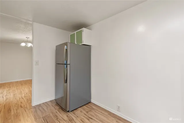 a view of a refrigerator in kitchen and wooden floor