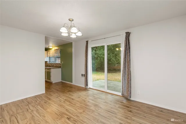 a view of a kitchen with wooden floor and a window
