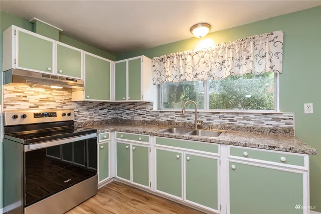 a kitchen with stainless steel appliances granite countertop a stove and a sink