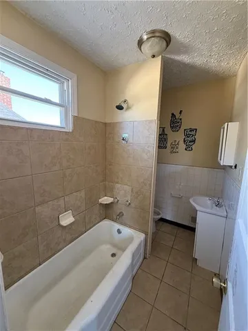 a bathroom with a tub a toilet and a shower
