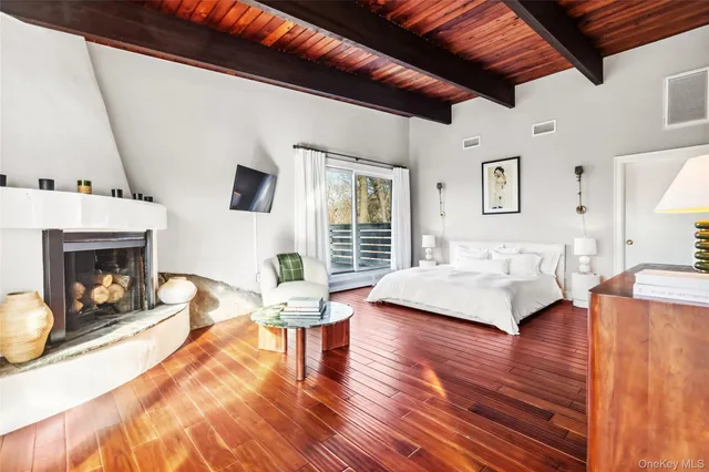 a bedroom with furniture large window and wooden floor
