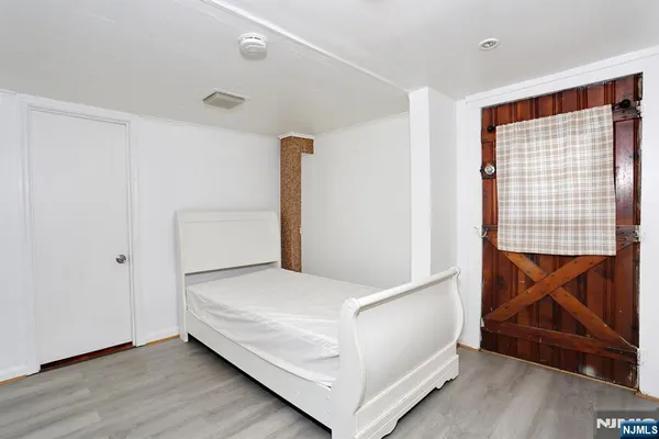 a view of bedroom with a bed and wooden floor