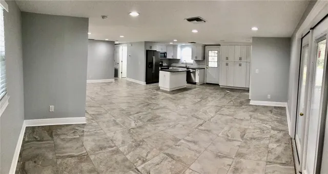 a view of kitchen with refrigerator stove microwave and cabinets