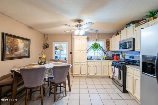 a kitchen with a stove a sink dishwasher a dining table and chairs with wooden floor