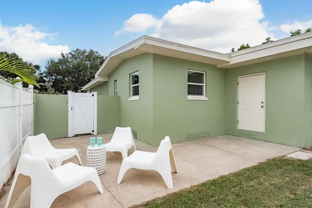 a backyard of a house with table and chairs