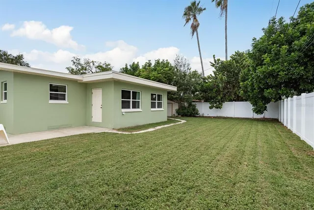 a backyard of a house with plants and a garden