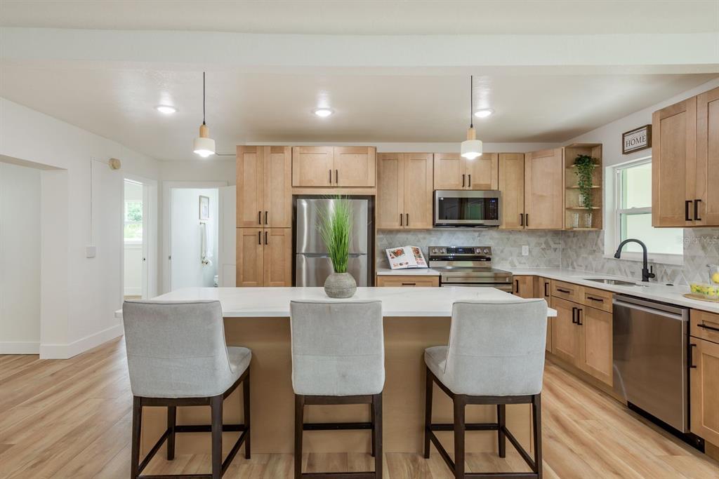 1448 Lemon Street Clearwater, FL 33756 - Photo 7 of 33 a kitchen with stainless steel appliances granite countertop a dining table chairs refrigerator and cabinets