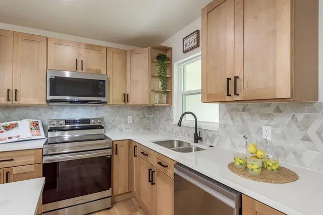 a kitchen with stainless steel appliances granite countertop a sink stove and microwave