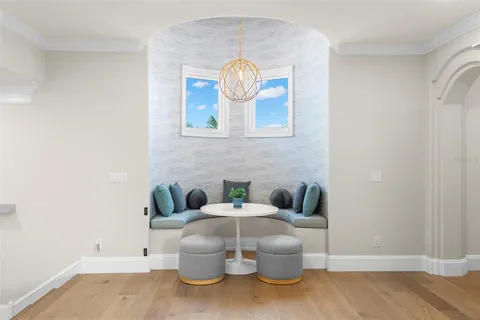 a view of a patio with a table and chairs under an umbrella with a small yard