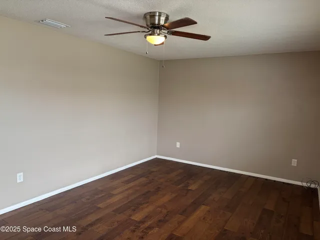 a view of an empty room with ceiling fan