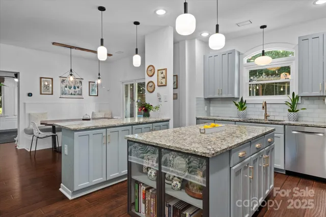 a kitchen with stainless steel appliances granite countertop a sink a stove a counter space and a center island