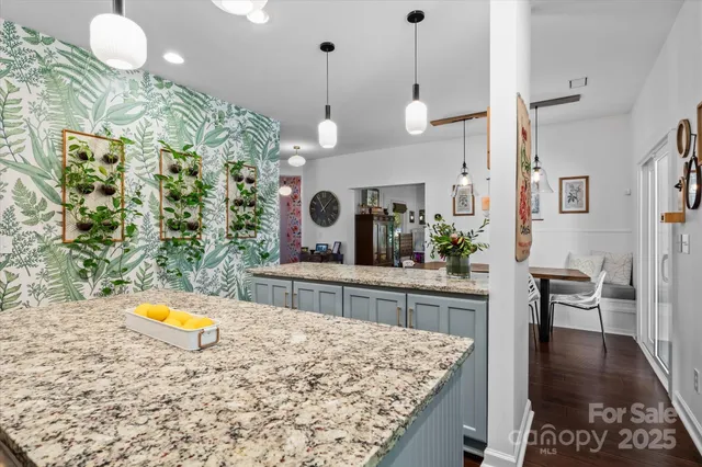 a kitchen that has a lot of cabinets a sink and a wooden floor