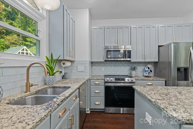 a kitchen with granite countertop a sink stove and cabinets