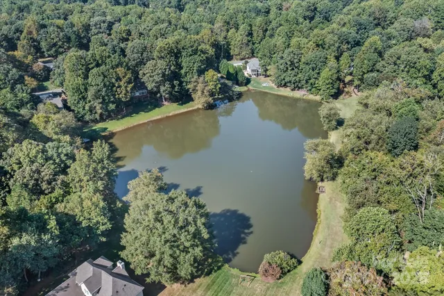 an aerial view of a house with a yard and lake view