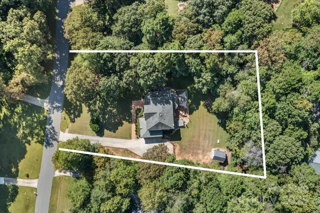 an aerial view of a house with a yard basket ball court and outdoor seating