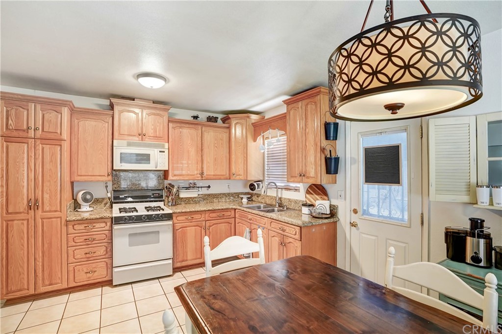 10223 25th Street Rancho Cucamonga, CA 91730 - Photo 8 of 17 a kitchen with stainless steel appliances a stove a sink and white cabinets