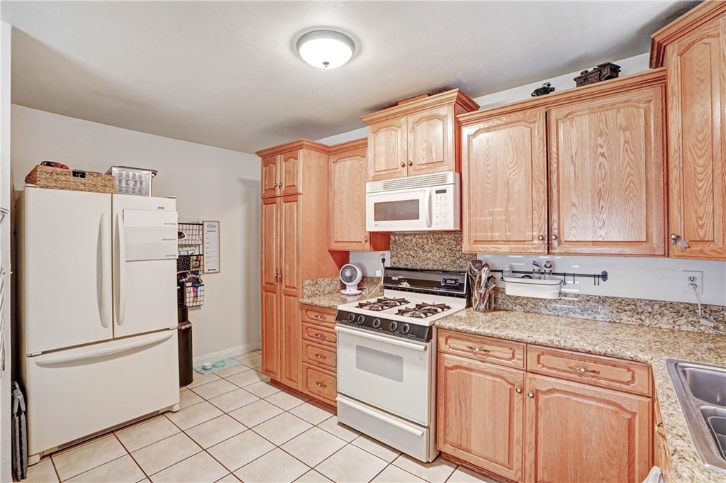 10223 25th Street Rancho Cucamonga, CA 91730 - Photo 10 of 17 a kitchen with stainless steel appliances a refrigerator sink and cabinets