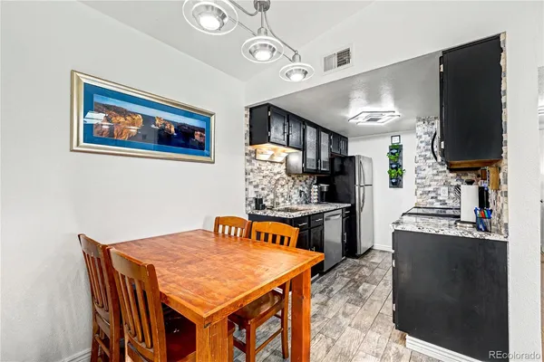 a kitchen with stainless steel appliances granite countertop a stove refrigerator and cabinets