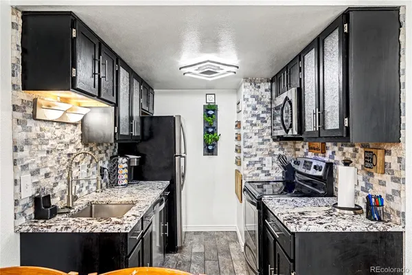 a kitchen with stainless steel appliances granite countertop a stove sink and cabinets