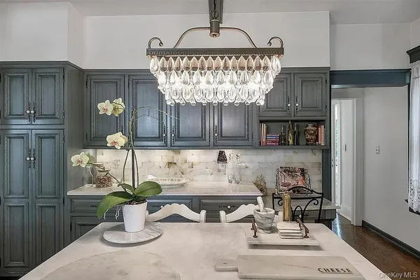 a kitchen with a stove a sink and chairs
