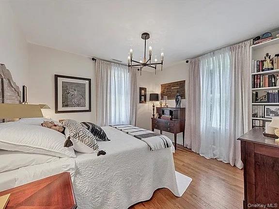 421 Spring Street Monroe, NY 10950 - Photo 38 of 49 a bedroom with a bed and a chandelier