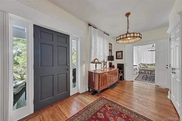 a living room with furniture a flat screen tv and a chandelier