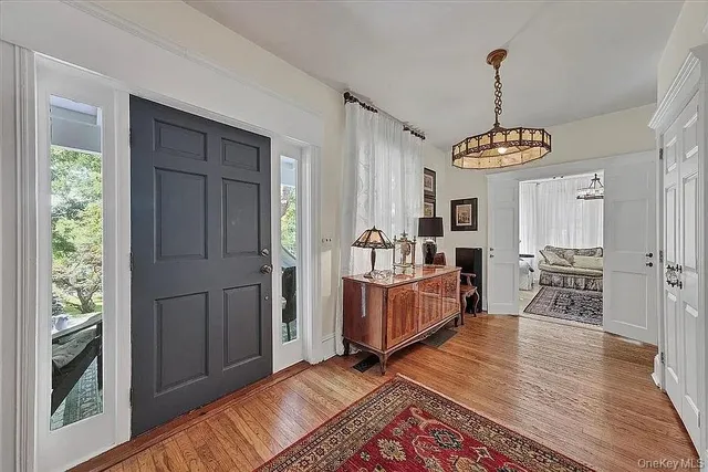 a living room with furniture a flat screen tv and a chandelier