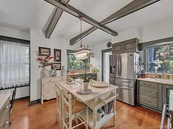 a view of a dining room with furniture a chandelier and wooden floor