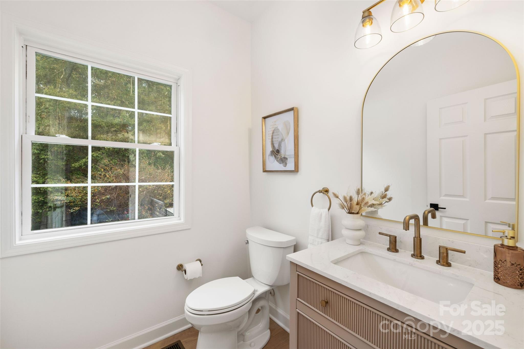 15906 Youngblood Road Charlotte, NC 28278 - Photo 18 of 41 a bathroom with a granite countertop toilet a sink a mirror and a window