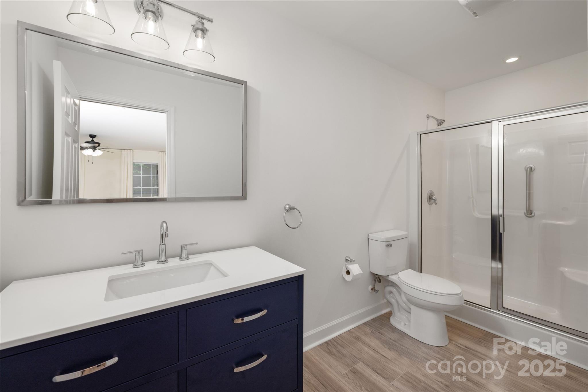 15906 Youngblood Road Charlotte, NC 28278 - Photo 33 of 41 a bathroom with a sink a toilet a large mirror and shower