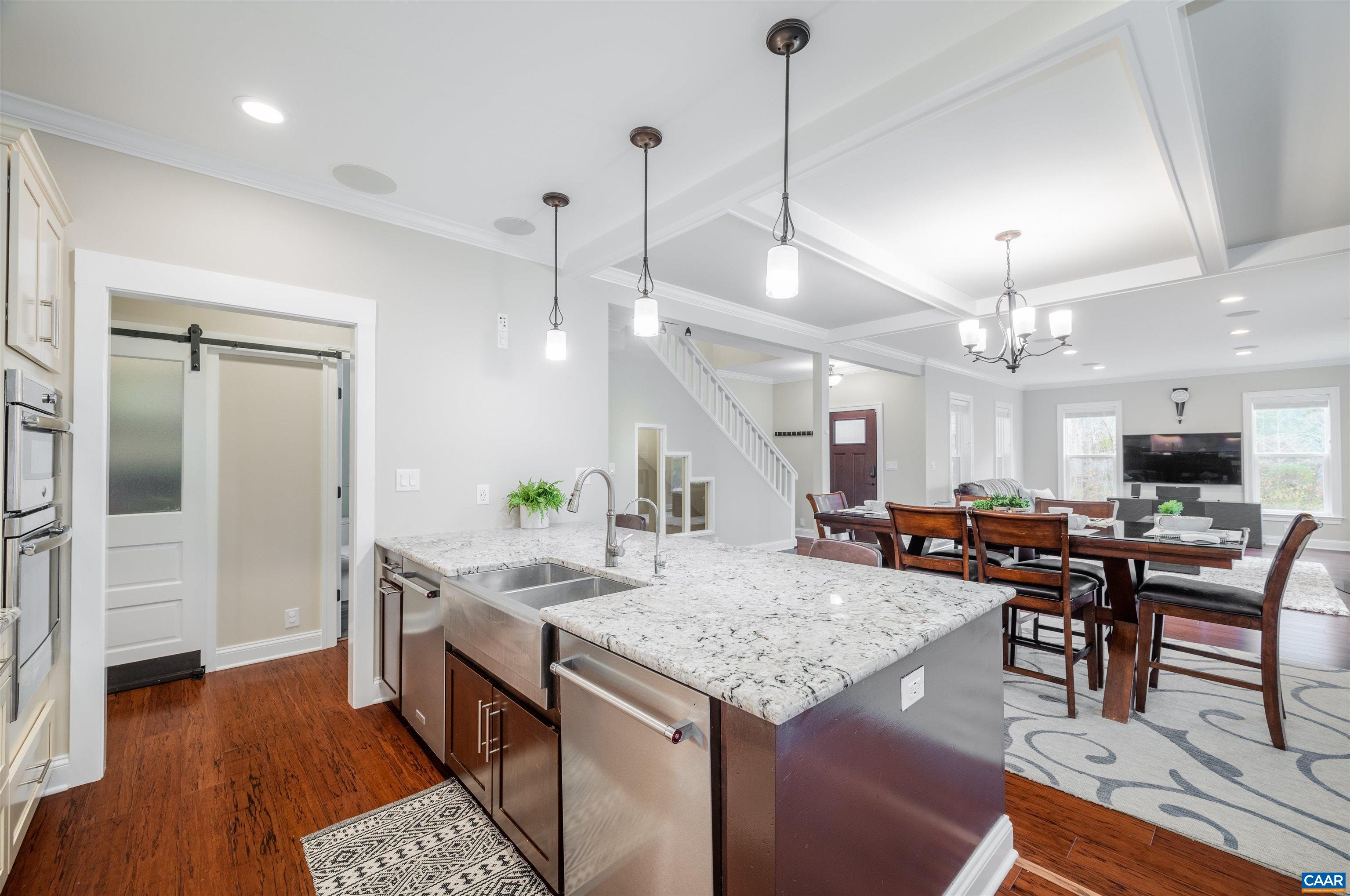 303 Turkey Ridge Road Charlottesville, VA 22903 - Photo 13 of 49 a view of a dining room and livingroom with furniture wooden floor a rug a fireplace and a chandelier